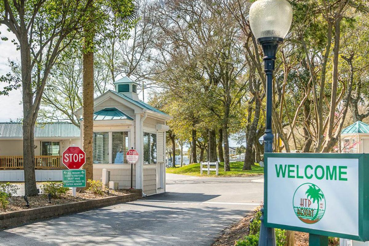 Campground entrance with green trees towering above.