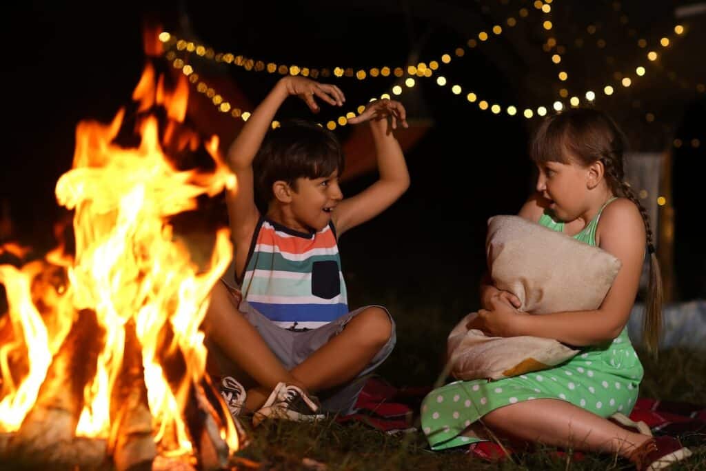 Little children near fire on summer evening