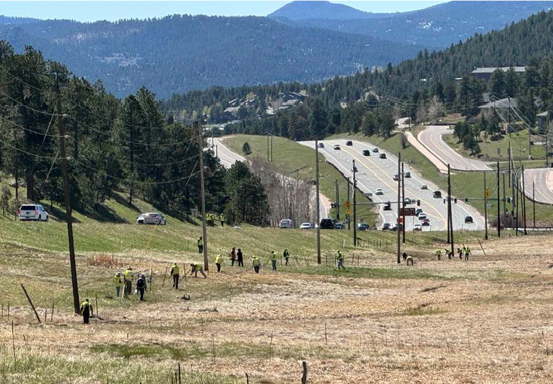 Volunteers remove old barbed wire fencing along a highway in Colorado.