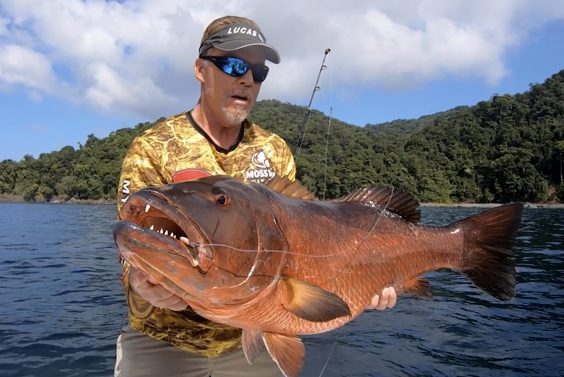 Mark Davis, a fisherman, holds up a big toothy fish.