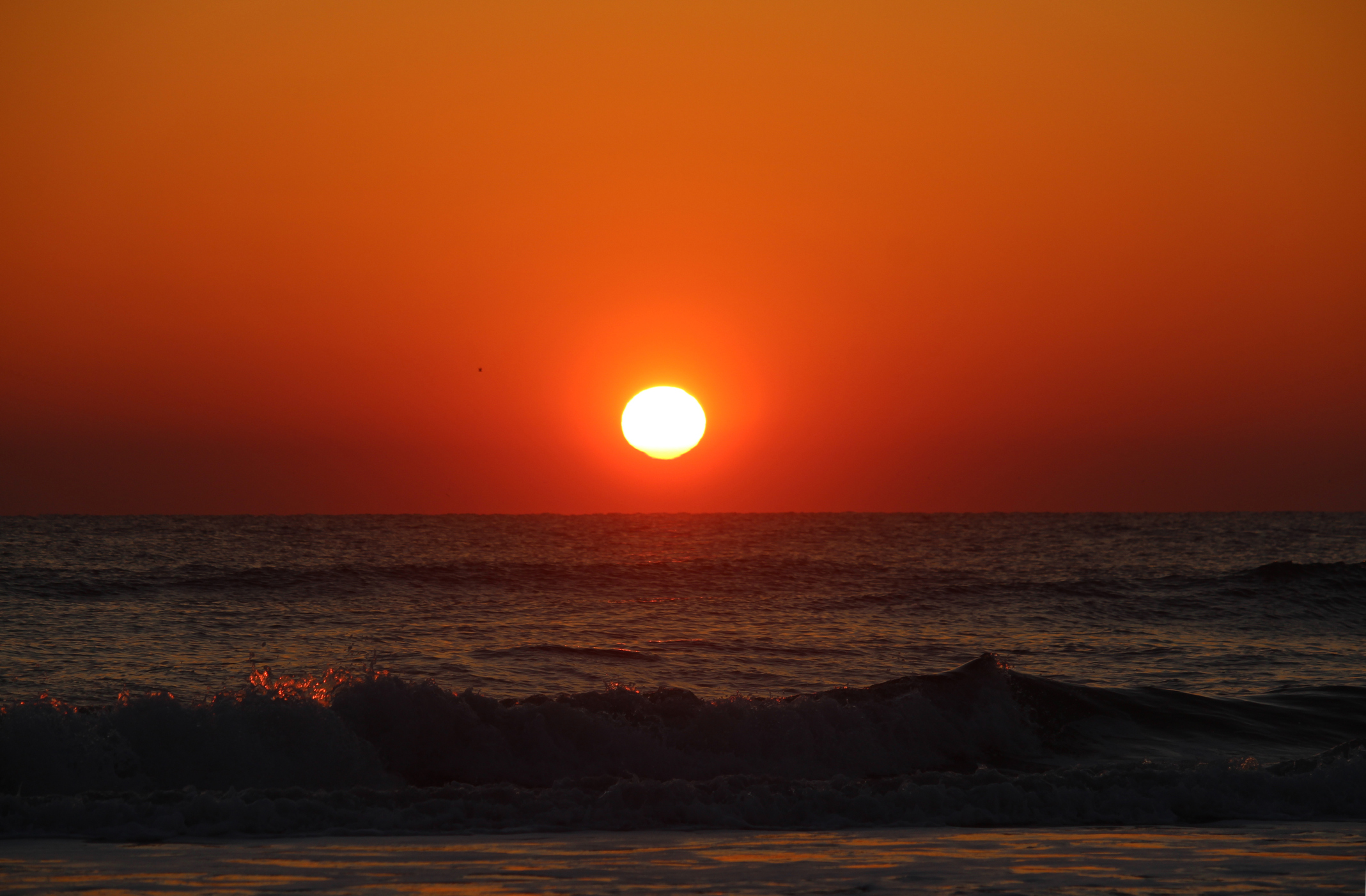 Beautiful sunrise reflects across the calm water of the ocean. Travel. Nature.