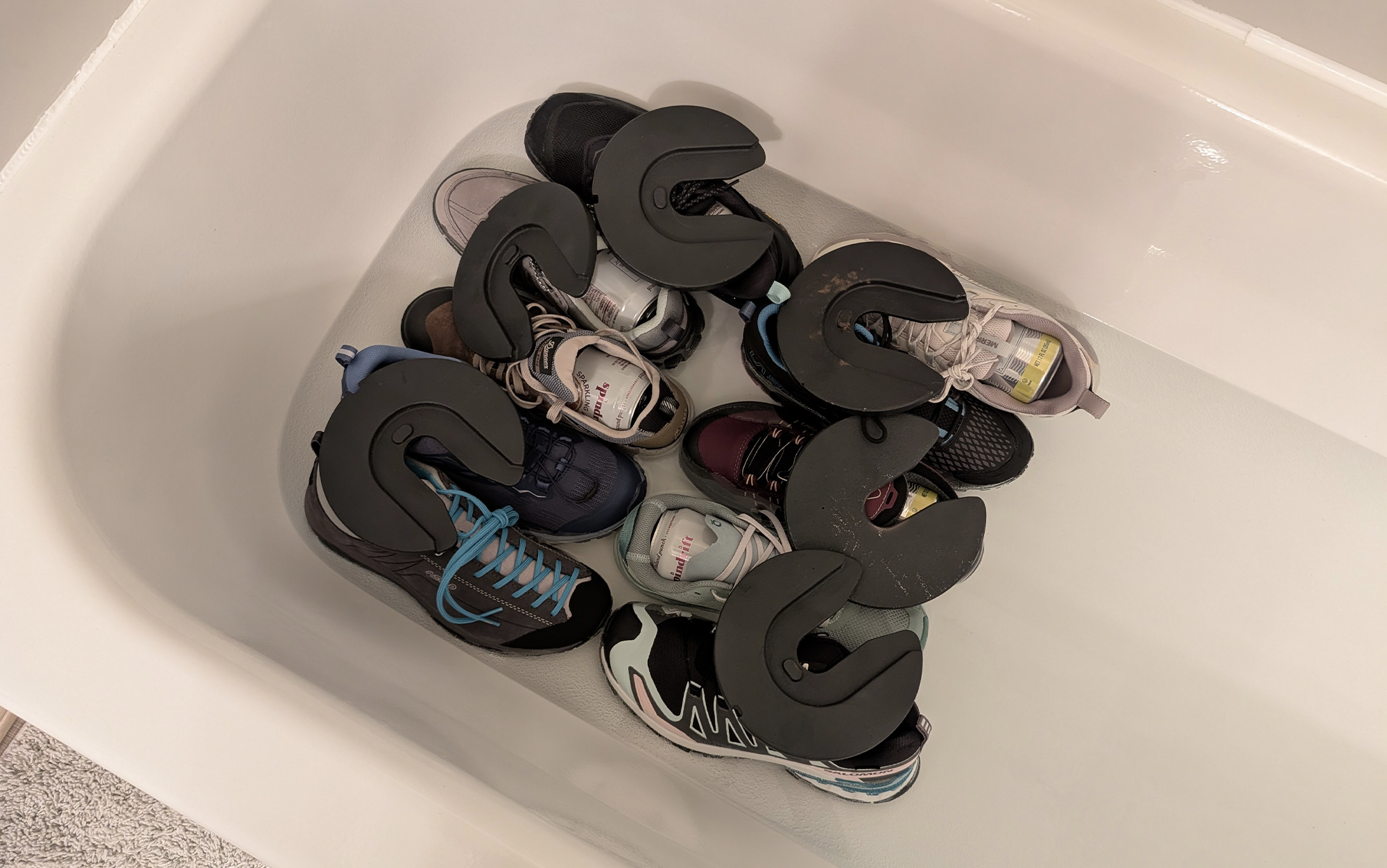 waterproof hiking shoes sitting in standing water in a tub with weights on top