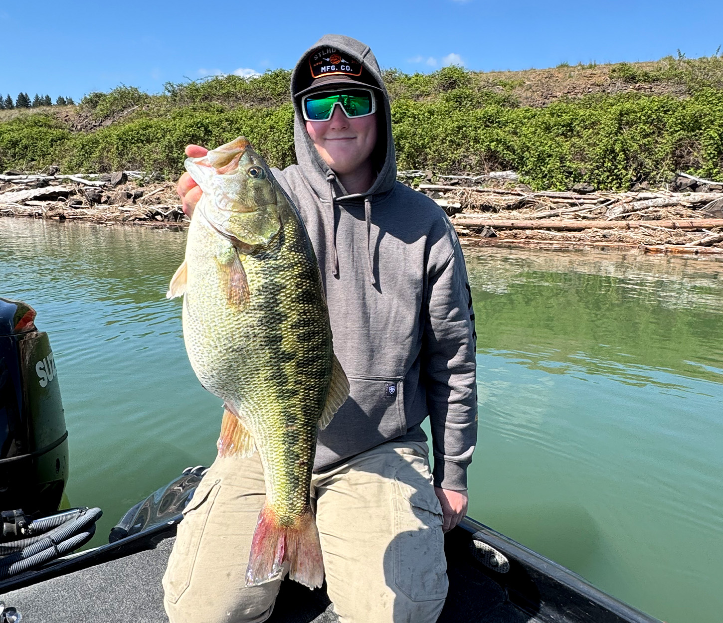 A bass angler holds up a big spotted bass.