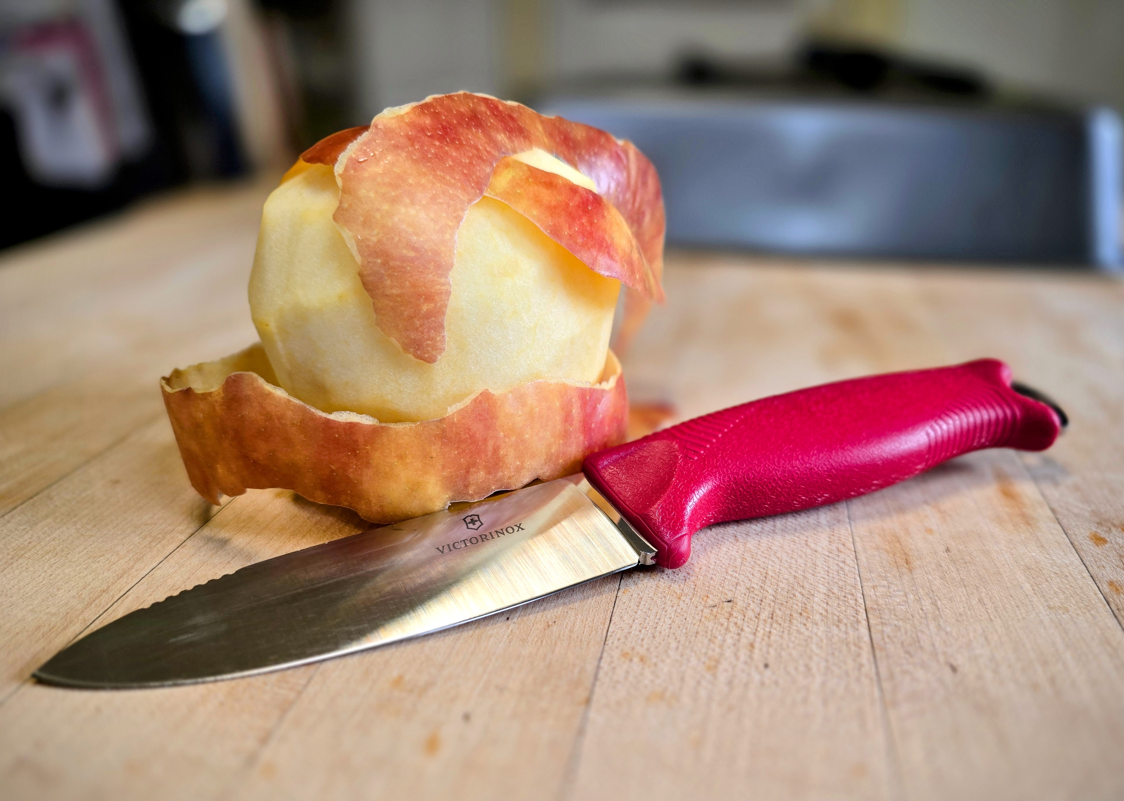 A red Victorinox Venture and a peeled apple.