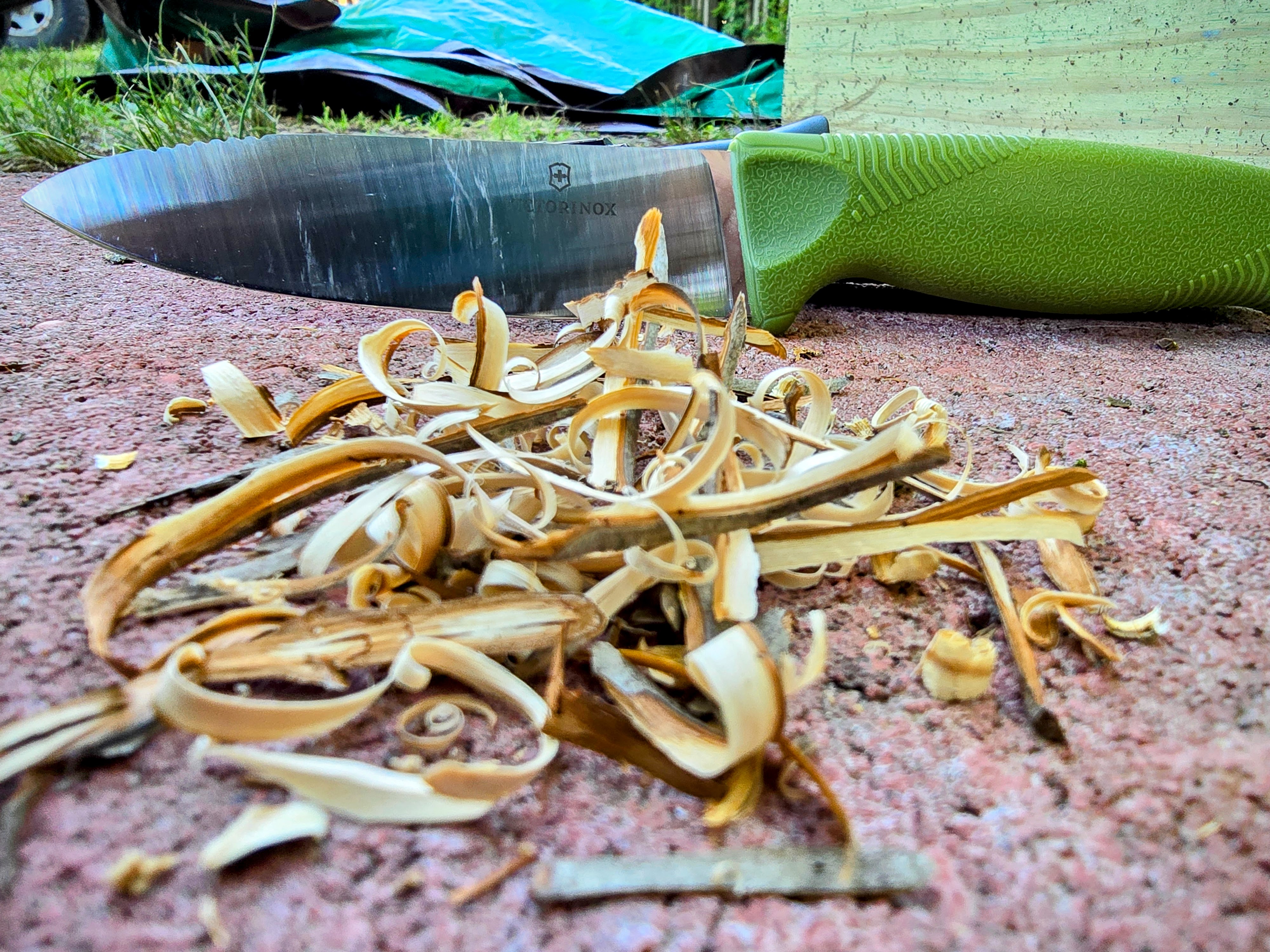 A green Victorinox Venture with wood shavings.