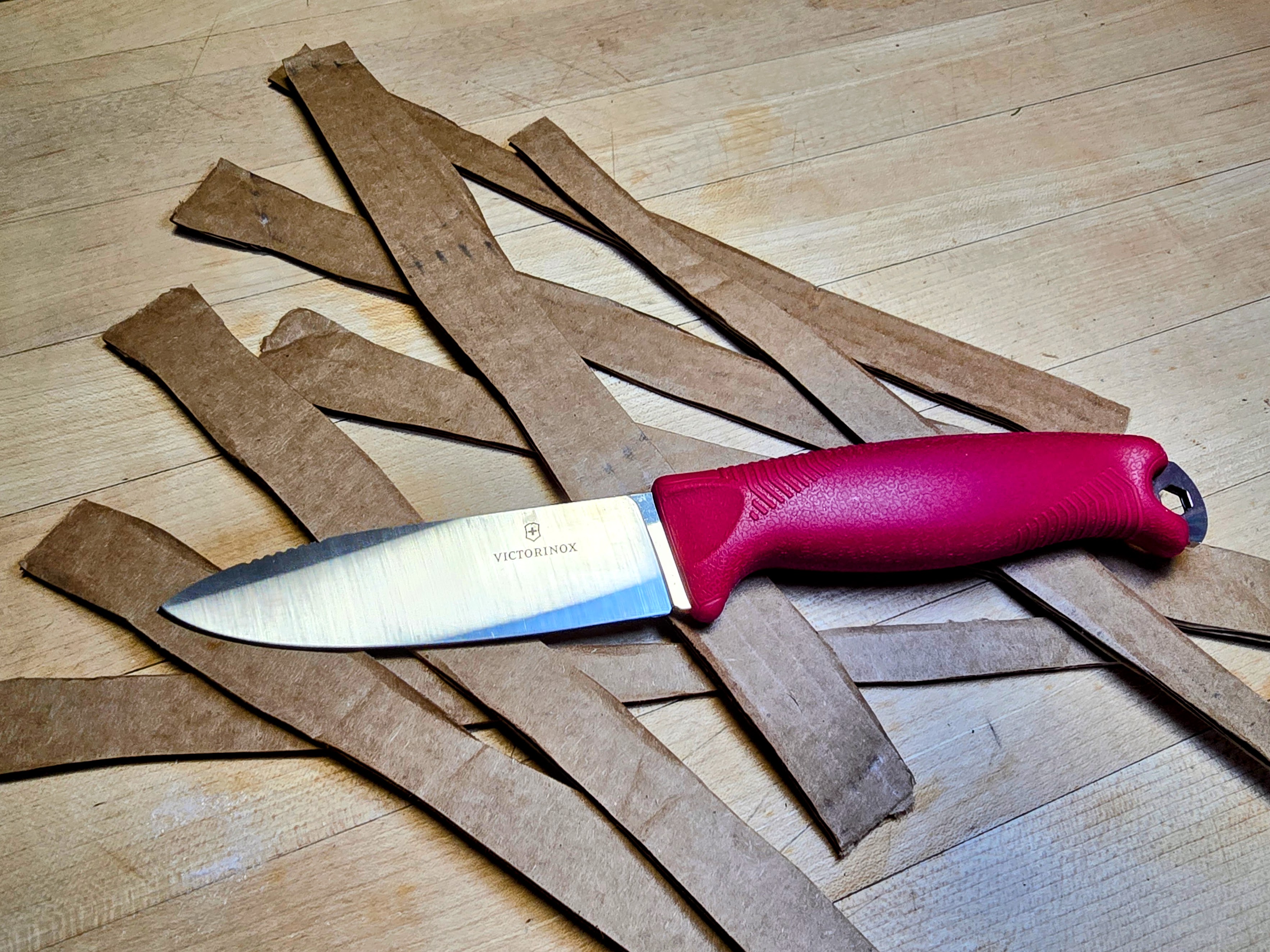  A red Victorinox Venture and cardboard strips.