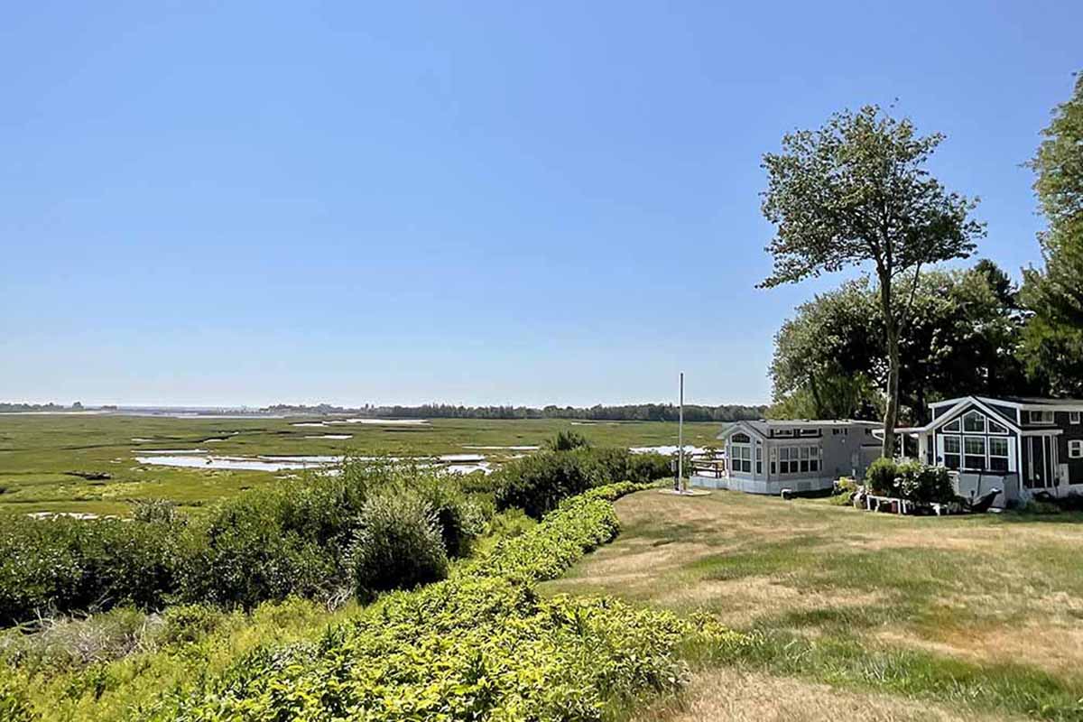 Two park models sit on a bluff overlooking sweeping wetlands.