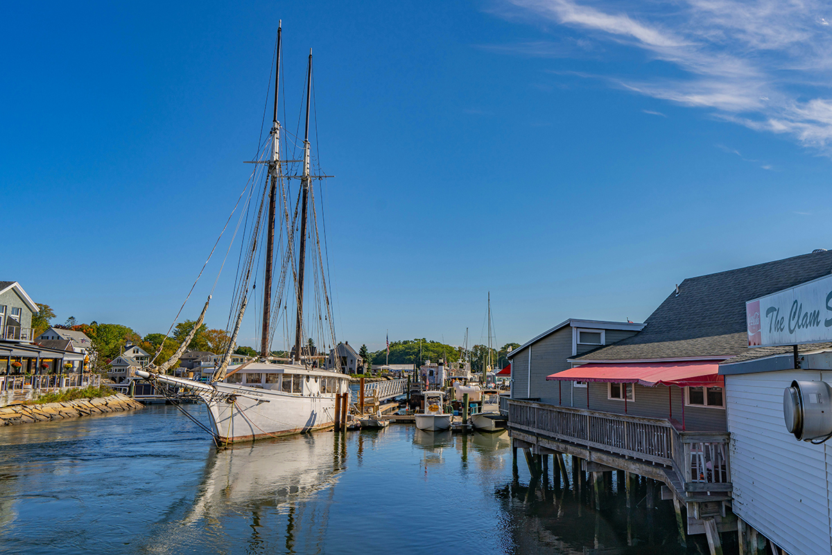 Two masted white sailboat moored on tranquil waters.