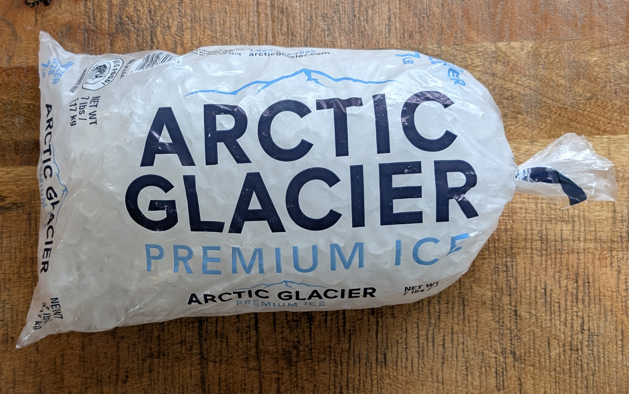 bag of ice sitting on a wooden table