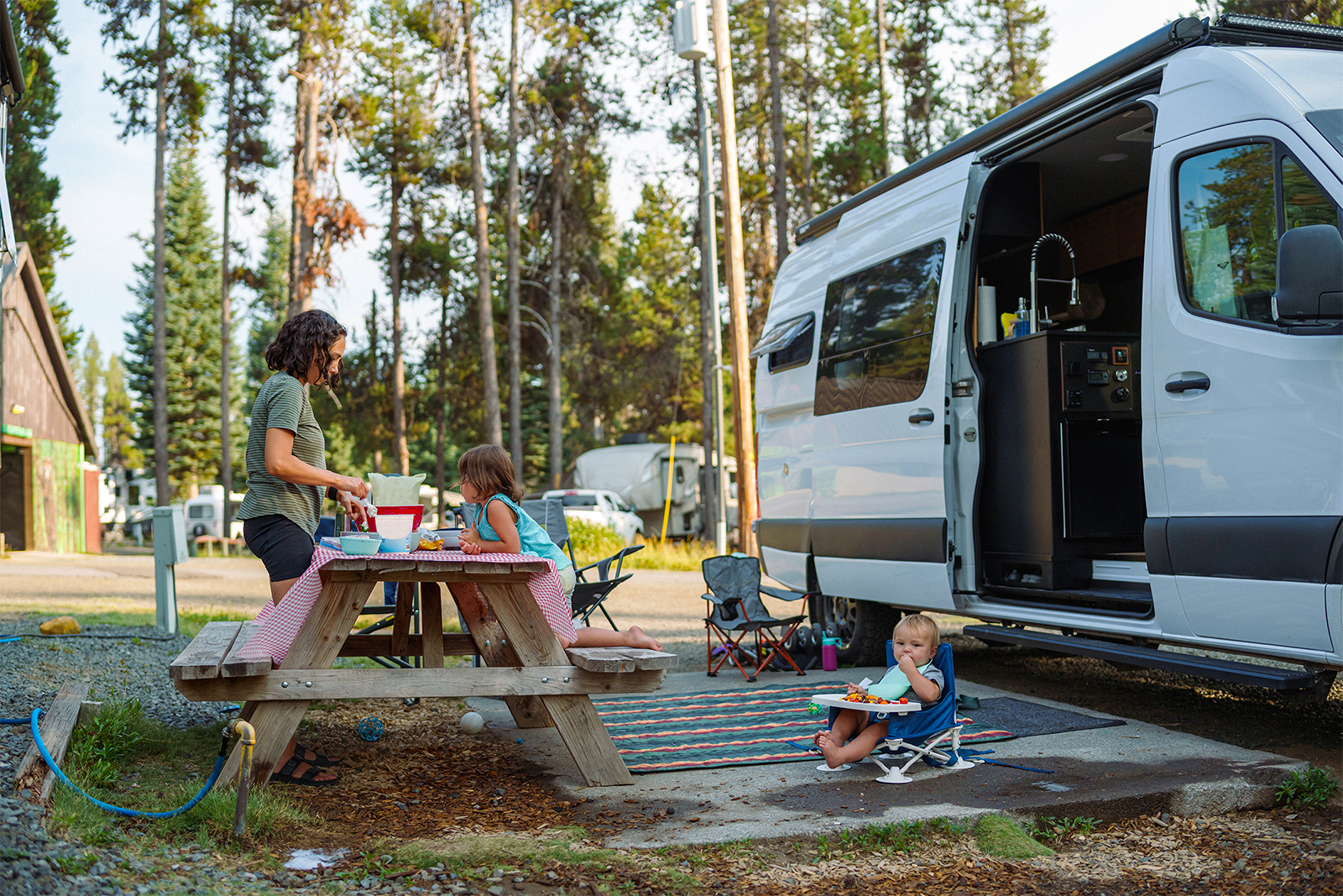 Family camping outside campervan