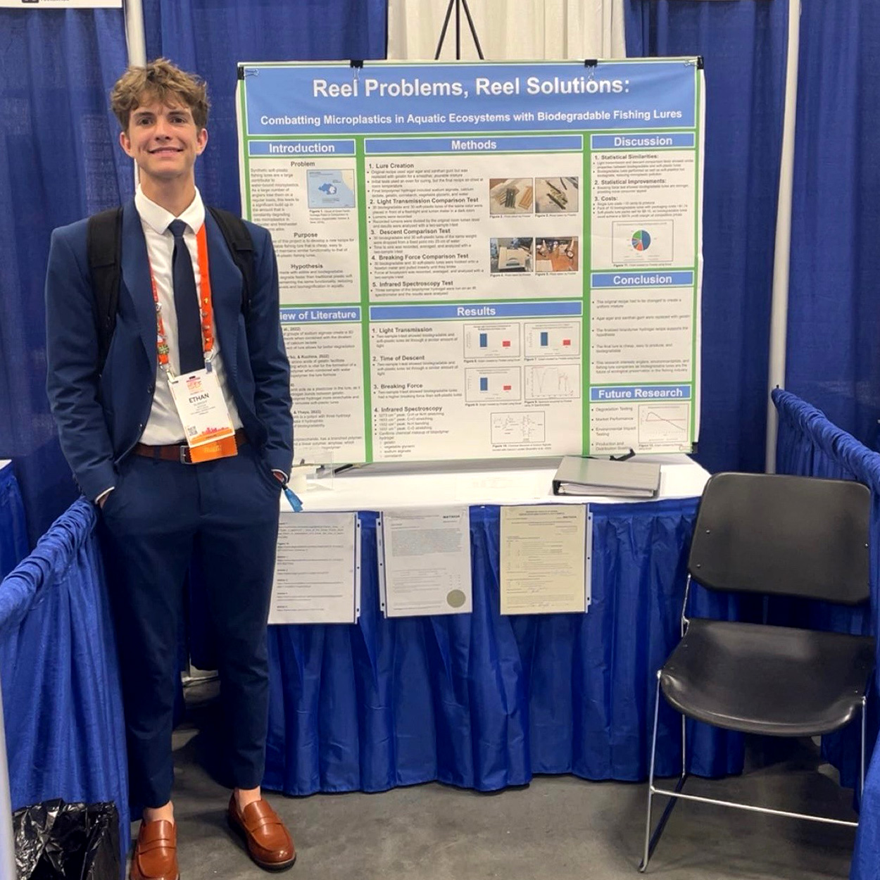 A science fair winner stands in front of his project.