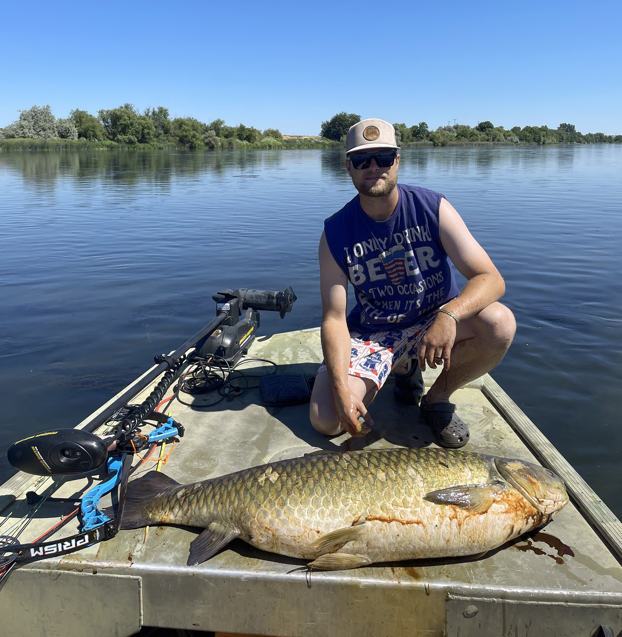 An Idaho bowfisherman with a giant grass carp taken from his boat.